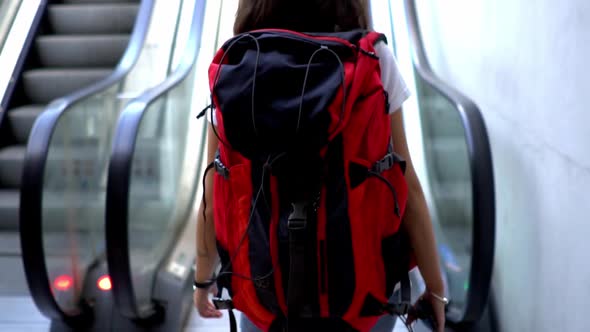 Female tourist with backpack on escalator