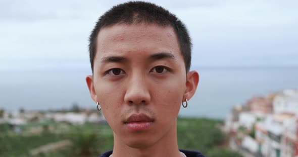 Asian boy looking serious on camera outdoor