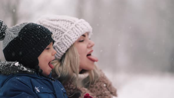 Cute Toddler Boy with Mother Catching Snowflakes with Mouth Funny Slow Motion Footage