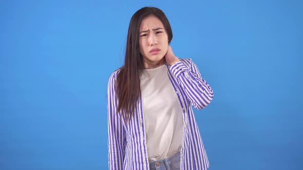 Beautiful Young Asian Woman with Neck Pain Standing on a Blue Background