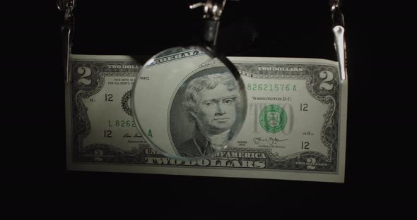 Two Dollar Us Banknote. $ 2 Cash Through A Magnifying Glass. 2 Bucks On Black.