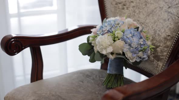 Bouquet of White Roses and Blue Flowers. Wedding Bouquet of the Bride on Chair