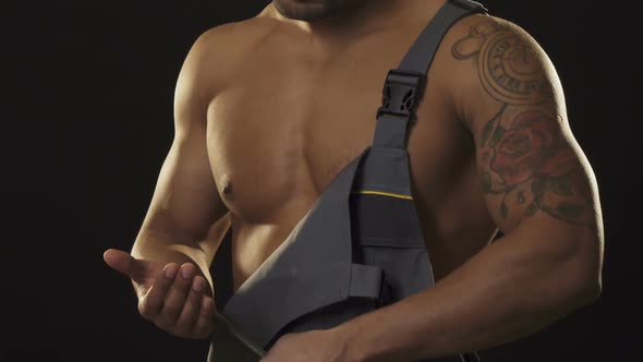 Ripped Muscular Mechanic in Workwear Looking Aggressive Holding a Wrench