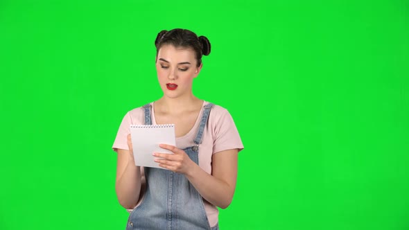 Girl Stands and Thinks, Then Writes with Pencil in Notebook