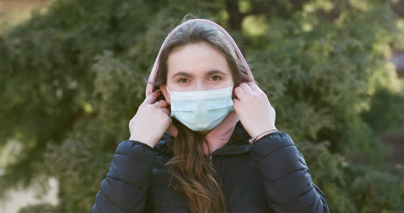 Girl Takes Off Medical Mask Isolated on Sunset Background