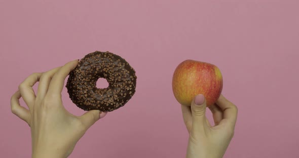 Hands Holds Donut and Apple. Choice Donut Against Apple. Healthy or Junk Food