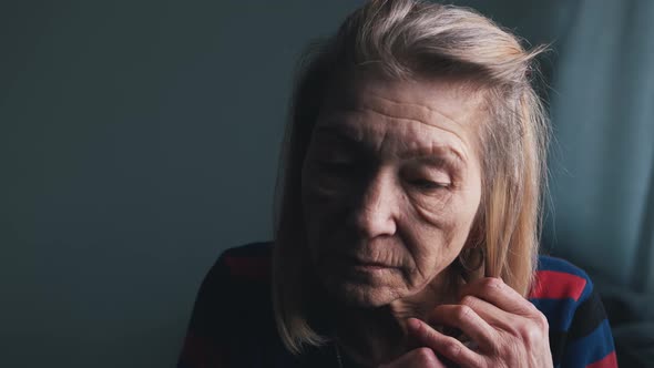 Pensive Elder Woman Adjusting Her Gray Hair