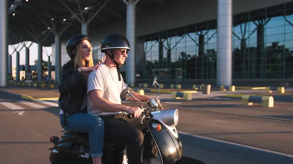 Happy Young Couple Riding Vintage Scooter on Urban Background and Having Some Fun Slow Motion