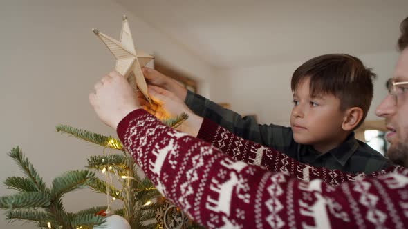 Father and son decorating the Christmas tree. Shot with RED helium camera in 8K