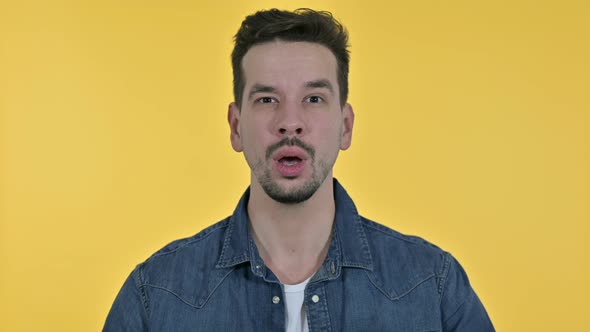 Portrait of Disappointed Young Man Reacting To Failure, Yellow Background