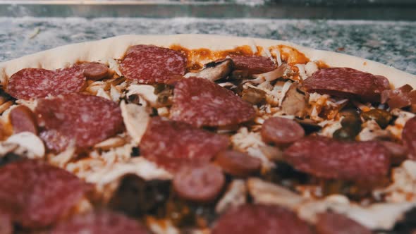 Appetizing Raw Pizza Dough with Chopped Ingredients Lies on the Kitchen Surface.