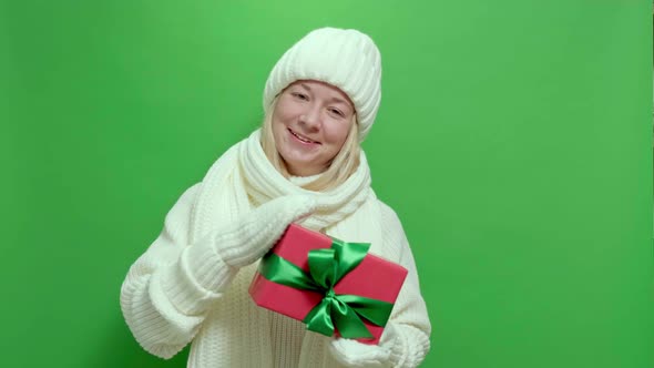 Young Smiling Woman Wearing White Knitted Sweater with Present Box