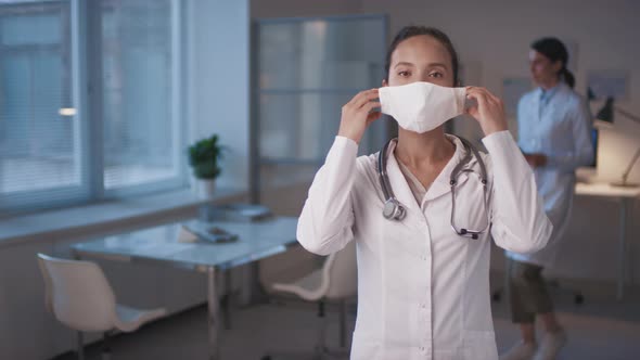 Female Doctor Putting on Mask
