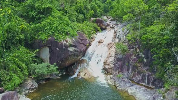 Mountain River with High Rapids Falls Into Blue Lake in Jungle