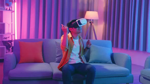 Young Asian Man Wearing Vr Headset And Dancing At Living Room, Cyan And Magenta Colors