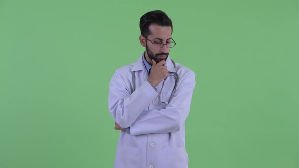 Stressed Young Bearded Persian Man Doctor Thinking and Looking Down