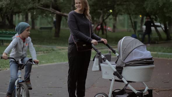 Mother Walking with Baby and Elder Son Outdoor