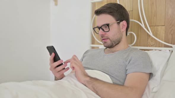 Beard Young Man Using Smartphone in Bed