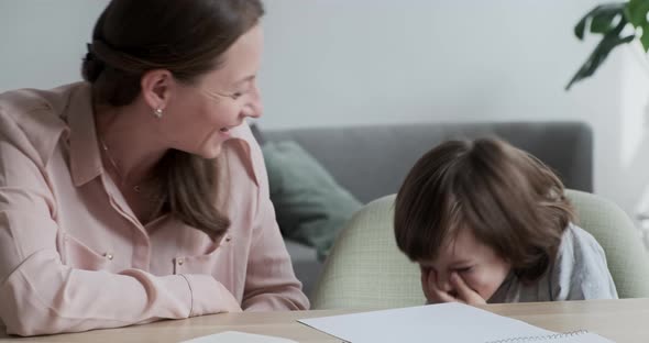Mother and Cute Son are Laughing and Having a Happy Time While Learning and Homeschooling