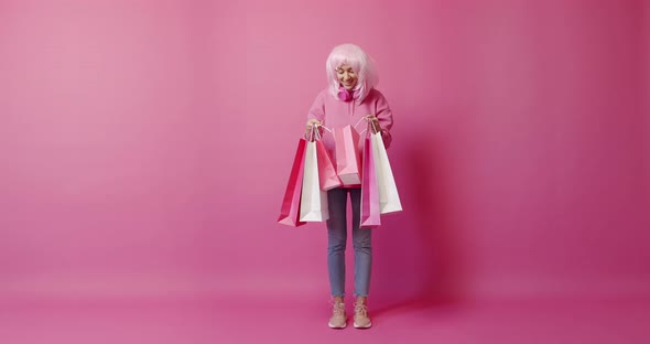 Happy Girl After Successful Shopping Isolated on Pink Background Studio Portrait