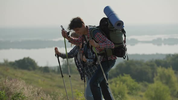 20s Tourist Couple with Travel Backpacks Looking at Mobile Phone Navigation Application