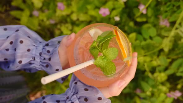 Woman Hands Holding and Rotate Glass with Alcoholic Cocktail Eco Paper Straw