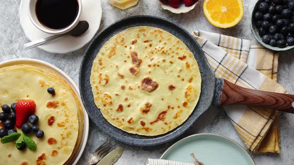 Delicious Pancakes on Stone Frying Pan. Placed on Table with Various Ingredients