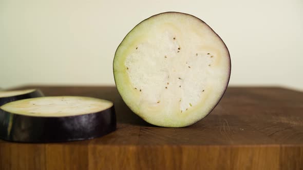 Chopping Eggplant. Closeup of Sliced Vegetable on Wooden Cutting Board. Stop Motion Animation