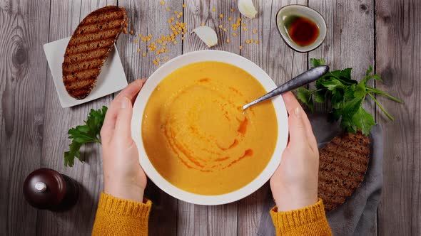 Top View of Unrecognisable Woman in Orange Sweater Eating Warm and Spicy Winter Lentil Soup