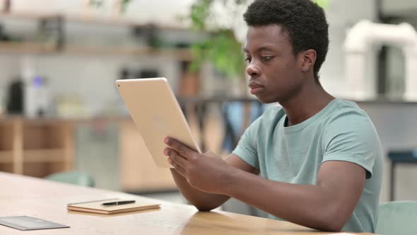 Young African Man Reacting To Loss on Tablet