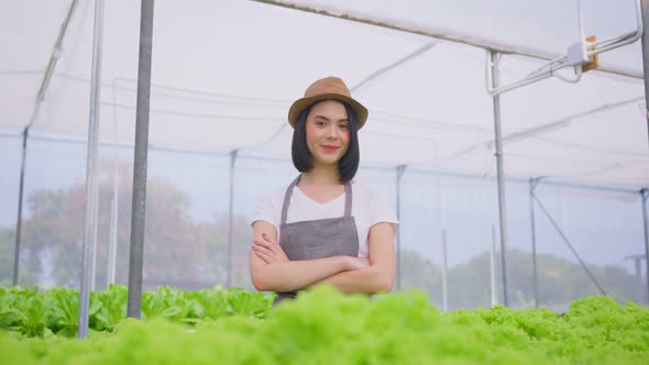 Portrait of Asian female farmer owner work in vegetables hydroponic greenhouse farm with happiness.