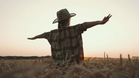 Happy Girl Child Plays Pilot on Wheat Field at Sunset