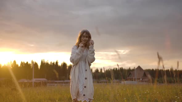 Cheerful Romantic Woman Walking in Field During Sunset