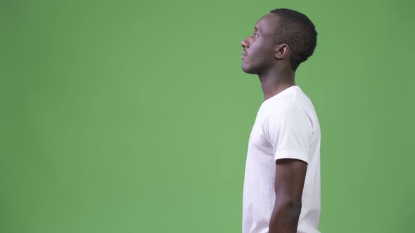 Profile View of Young African Man Against Green Background
