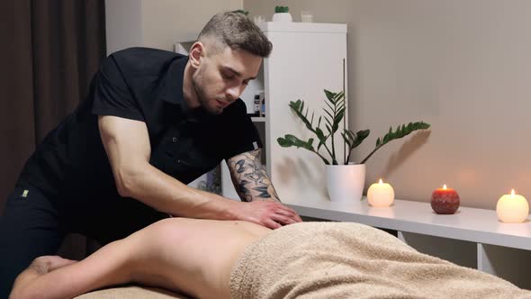 Masseur doing massage on man body in the spa salon. Beauty treatment concept