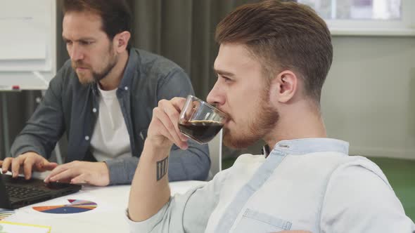 Bearded Handsome Young Businessman Drinking Coffee Thinking Looking Away