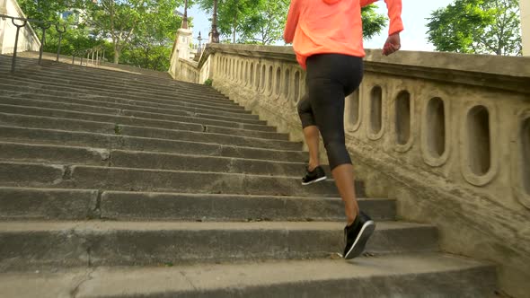 Closeup of legs on a woman running on stairs in a city for a workout