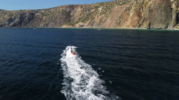 Happy People Swim on Air Mattress Behind a High Speed Water Bike