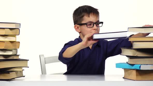 Boy Sits at a Table and Reading a Book. White Background