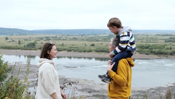 Family admiring the landscape from the cliff of the river