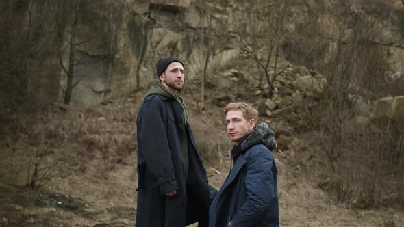 Two Friends In Nature. Stylish Young Guys. One Standing On Stone Above The Other.