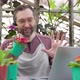 Man Sells Flowers and Seedlings Via Video Link on a Laptop Via the Internet - VideoHive Item for Sale