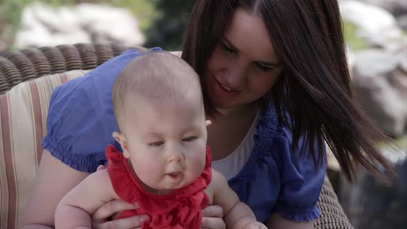 Slow motion of woman kissing baby girls check.