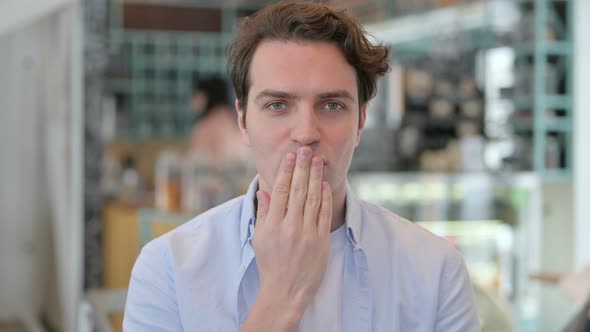 Portrait of Attractive Young Man Giving Flying Kiss