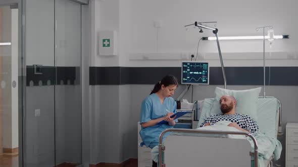 Medical Nurse Discussing Illness Treatment with Hospitalized Sick Man