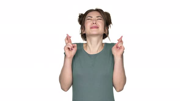 Portrait of Young Woman with Double Buns Hairstyle Beseeching God Please and Keeping Fingers Crossed