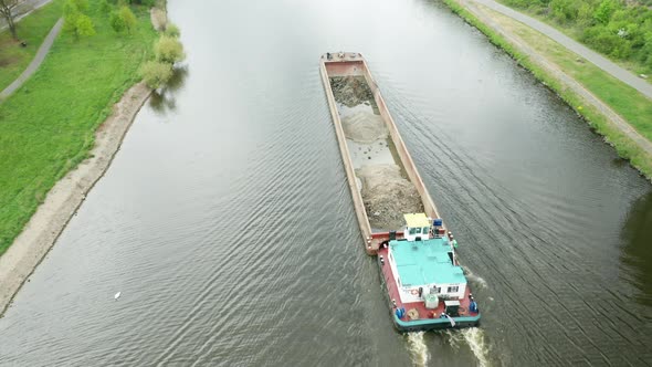 Aerial View of Large Cargo Barge Moving Along the River