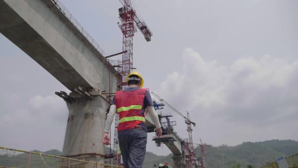Engineering Walking Near Construction Bridge Crossing River alt