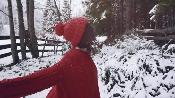 Attractive Young Beautiful Woman Walking in Winter Snowy Forest. Happy Portrait of Asian Girl While