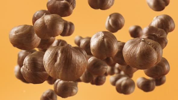 Flying of Hazelnuts in Pale Orange Background